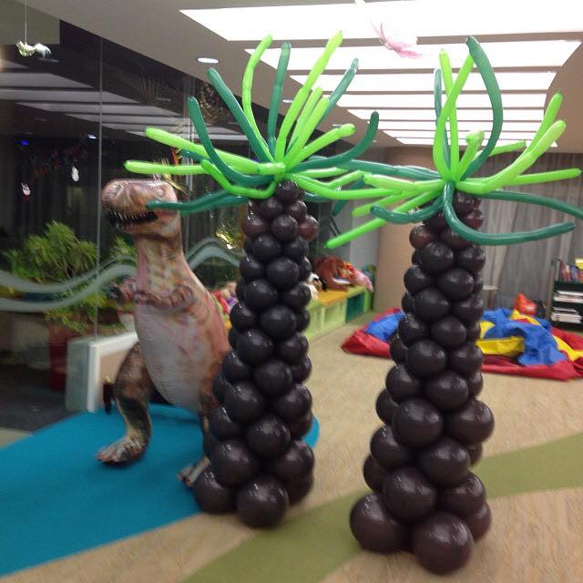 Palm tree balloon columns with dinosaur