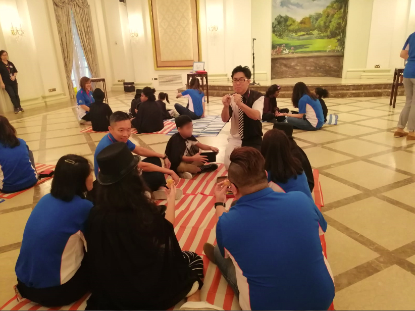 Mr Bottle's teaching children from Singapore Children's Society some simple magic so they can perform for the President later at the Istana